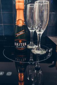 a bottle of beer and two wine glasses on a table at Loveroom Pau in Pau +9 photos
