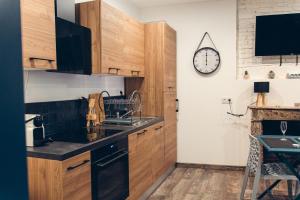 a kitchen with wooden cabinets and a clock on the wall at Loveroom Pau in Pau
