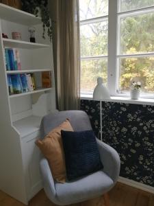 einen Stuhl mit Kissen in einem Zimmer mit Fenster in der Unterkunft Sinnerskog - Urlaub im alten Bahnhof in Högsby