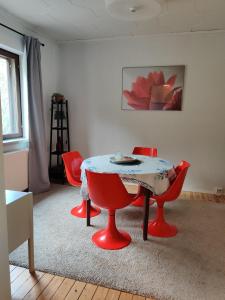 Habitación con mesa y 4 sillas rojas en Vintage Retreat, en Lahti