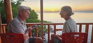 Ein Mann und eine Frau, die auf einer Veranda auf Stühlen sitzen in der Unterkunft Likupang Homestay/Pondok Wisata in Likupang