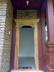 塔巴南的住宿－Purana Guest House，一道开敞的门,开向建筑上方,上面有钟