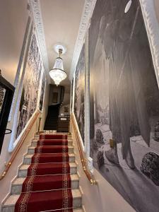 eine Treppe in einem Gebäude mit Gemälden an den Wänden in der Unterkunft BeyPort Hotel Taksim in Istanbul
