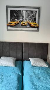1 dormitorio con 1 cama y 2 taxis amarillos en Apartament przy Parku Centralnym, en Gdynia