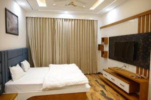 1 dormitorio con 1 cama y TV en Hotel Panache The Escape - Home Stay, en Jhālāmand