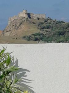 a castle sitting on top of a hill next to a body of water at Villa Vue sur Mer in Tabarka