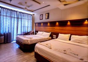 a hotel room with two beds and a window at HOTEL SEBAA PALACE in Kanyakumari