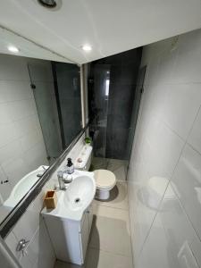 a bathroom with a sink and a toilet and a mirror at Hermoso apto frente al mar. in Montevideo