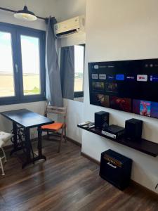 een kamer met een tafel, een tv en een bureau bij Hermoso apto frente al mar. in Montevideo