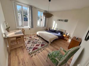 1 dormitorio con 1 cama, 1 mesa y 2 ventanas en Chambres d'Hôtes Stella Mare en Yport