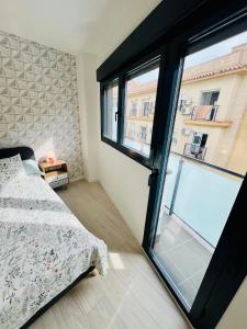 a bedroom with a bed and a large window at APTO DISEÑO CENTRO TORREMOLINOS in Torremolinos