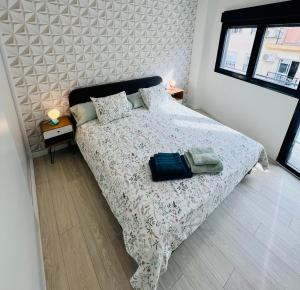 a bedroom with a bed with a comforter and pillows at APTO DISEÑO CENTRO TORREMOLINOS in Torremolinos
