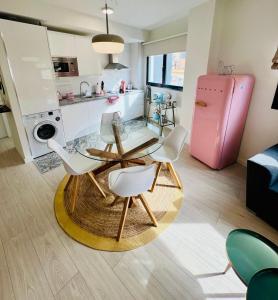 a living room with a table and chairs and a pink refrigerator at APTO DISEÑO CENTRO TORREMOLINOS in Torremolinos
