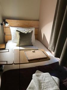 a small bedroom with a bed with a tray on it at South Downs Eco Lodge & Camping in East Meon