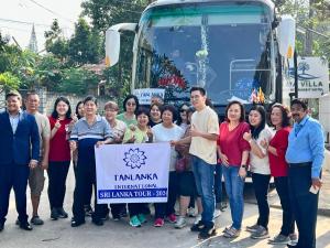 um grupo de pessoas em pé na frente de um ônibus em Diva Villa Airport Transit Hotel em Katunayaka