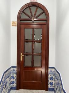 drewniane drzwi z oknem na ścianie w obiekcie Pino Grande 16 w mieście El Viso del Alcor