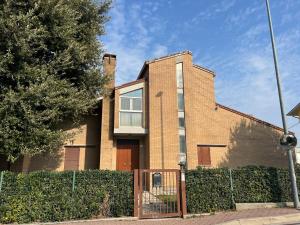 uma casa de tijolos com uma cerca em frente em Casa Mattioli em Mombaroccio