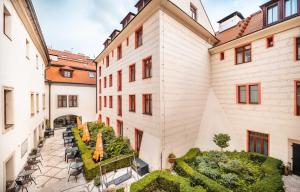 a courtyard in a building with chairs and umbrellas at Hotel Elite Prague in Prague