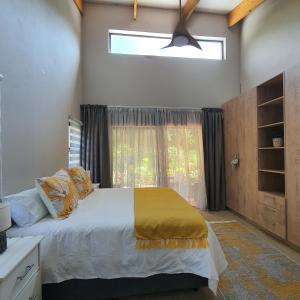 ein Schlafzimmer mit einem großen Bett und einem Fenster in der Unterkunft The Bird House in Kampersrus AH