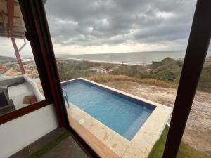 Blick auf den Pool aus dem Fenster in der Unterkunft Casa de Playa Koumpí Beach in Don Juan