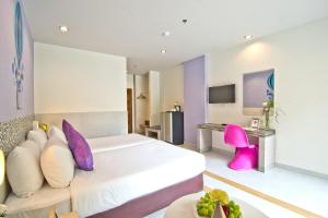 Habitación de hotel con cama y escritorio en Grand Bella, en Pattaya central