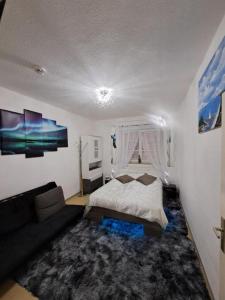 ein Schlafzimmer mit einem Bett und einem Sofa in der Unterkunft Complete Apartment peacefully situated near the Airport Nürnberg in Nürnberg