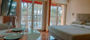 ein Schlafzimmer mit einem Bett und einem Tisch mit Brille darauf in der Unterkunft Alicantissima Marina & Beach in Alicante