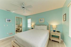 a bedroom with a bed and a ceiling fan at Anna Maria Island Beach Palms 6B in Bradenton Beach +83 photos