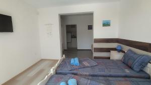 a bedroom with a bed with blue flip flops on it at Antorino in Balchik