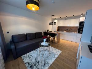 a living room with a couch and a table at Apartamentai JOLA in Vilkaviškis