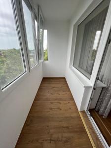 a hallway with two windows and a wooden floor at Apartamentai JOLA in Vilkaviškis