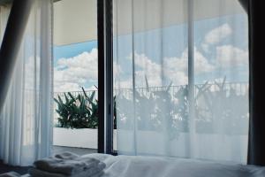 een slaapkamer met een raam dat uitkijkt op een plant bij Hotel Rakuragu in Tokyo