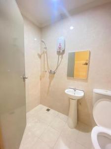 a bathroom with a shower and a toilet and a sink at The Grand Hotel 2 in Bandar Indah
