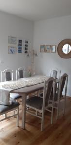 a dining room table with chairs and a table and a mirror at Willa Paulina in Nadole