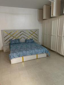 Un dormitorio con una cama con almohadas azules. en La belle étape, en Dakar