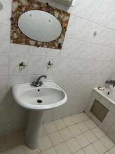 baño con lavabo y espejo en la pared en La belle étape, en Dakar