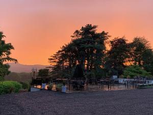 een groep tafels en een boom bij zonsondergang bij Uplands Inn Cartmel in Cartmel