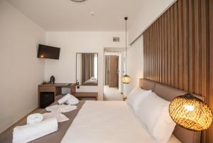 1 dormitorio con 1 cama con sábanas blancas y toallas en Verano Afytos Hotel en Afitos