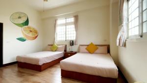 2 camas en una habitación con 2 ventanas en Dilly Dally B&B, en Gukeng