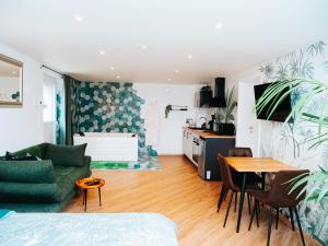 sala de estar con sofá verde y mesa en L'Oasis Tropicale, en Roppenheim