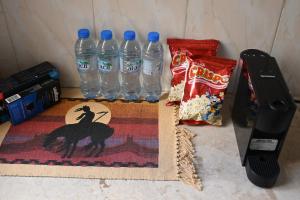 a counter with two bottles of water and some snacks at Stylish Hilltop King Bed Apartment with Free Parking and Wifi in Wuţayyah