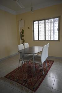 a dining room with a table and chairs on a rug at Stylish Hilltop King Bed Apartment with Free Parking and Wifi in Wuţayyah
