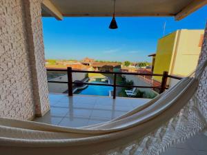 a hammock on the balcony of a house at Pousada Gostoso Paradise in São Miguel do Gostoso