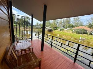 a porch with two chairs and a view of a river at Koh Yao Beach Front in Ko Yao Yai