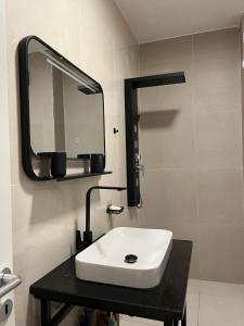 a bathroom with a white sink and a mirror at Sunshine Apt Qerret-Golem Beach in Golem