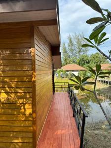 a wooden walkway leading to a house with a pond at Koh Yao Beach Front in Ko Yao Yai