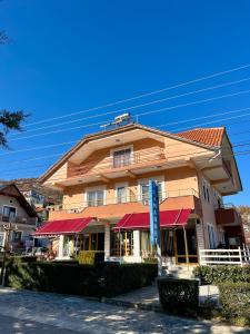 a large building with red awnings on a street at Eiffel's Guest House in Pogradec