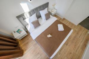 einen Blick über ein Schlafzimmer mit einem Bett mit weißen Kissen in der Unterkunft Пять НОВЫХ апартаментов БИЗНЕС КЛАССА в ЖК R-HOUSE в 100 м от MEGA in Almaty