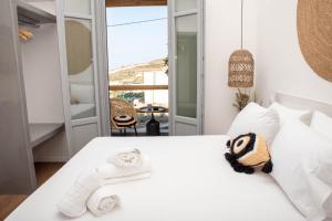 a bedroom with a white bed with a towel at Aidani Luxurious Rooms in Vóthon