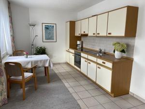 uma cozinha com armários brancos e uma mesa com um lavatório em Haus Sauer Bad Sassendorf em Bad Sassendorf